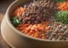 Hundeernährung: Was ist wirklich gesund? A hyperrealistic close-up of a dog bowl filled with a mix of dry kibble, fresh vegetables, and pieces of meat, representing a balanced diet. Soft, natural lighting highlights the textures. No text.