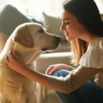 Hyperrealistic photorealistic image of a young woman kneeling and gently petting a Labrador Retriever, looking into its eyes with a gentle and understanding gaze. Soft, natural light streaming through a window illuminates a cozy living room setting. Shallow depth of field, focus on the connection between human and dog. Artefact-free, no text.